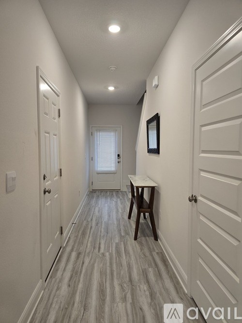 A long hallway with a table and chairs at the end.