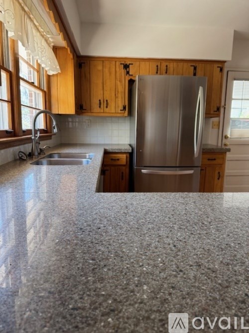 A kitchen with a granite countertop and stainless steel appliances.