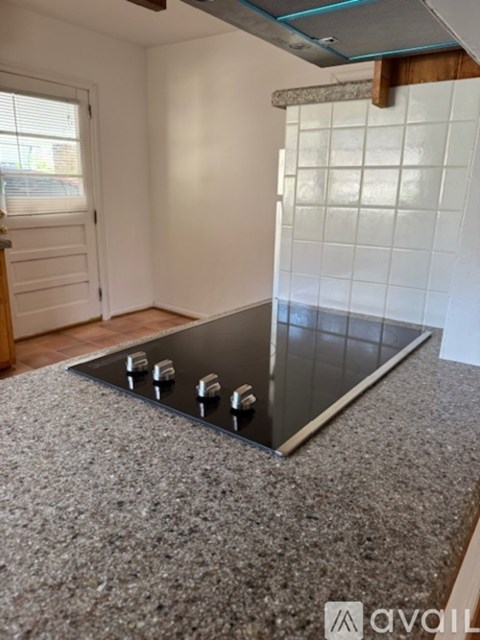 A kitchen counter with a stove top in the middle.