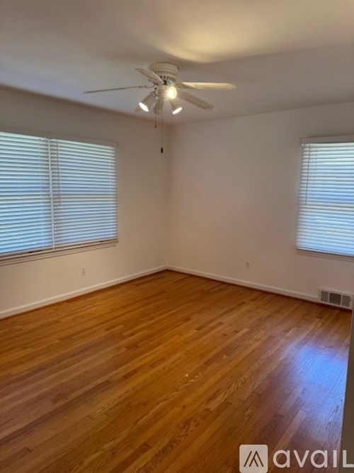 A room with wooden flooring and a ceiling fan.