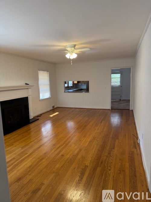 A living room with a fireplace and a flat screen TV mounted on the wall.