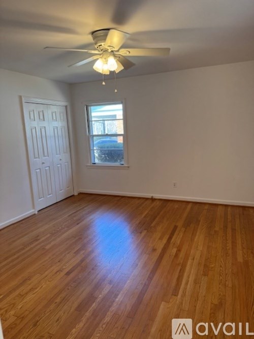 A room with wooden floors and a ceiling fan.