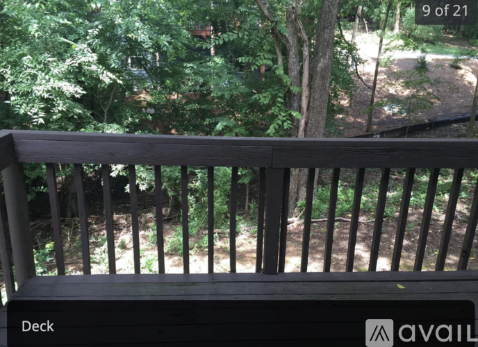 A wooden deck with a view of trees and a path.