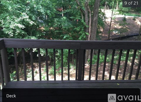 A wooden deck with a view of trees and a path.