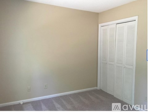 A room with a white door and carpeted floor.