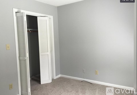A room with a white door and carpeted floor.