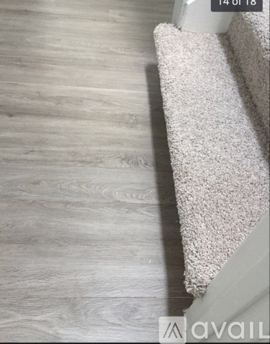 A white carpet is on a wooden floor.