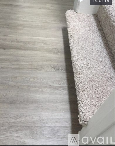 A white carpet is on a wooden floor.