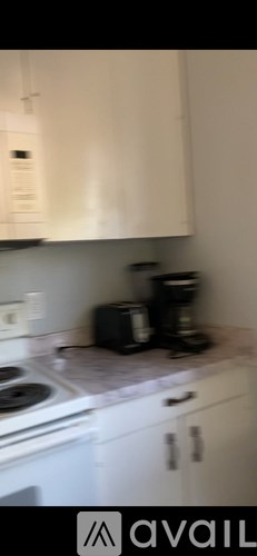 A kitchen with white cabinets and a stove top oven.