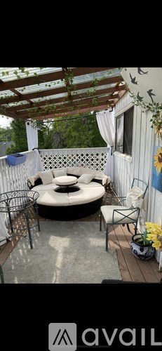 A patio with a round table and chairs under a pergola.