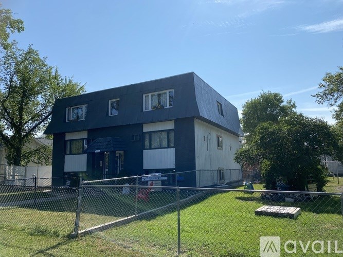 A blue and white two-story house with a fenced yard.