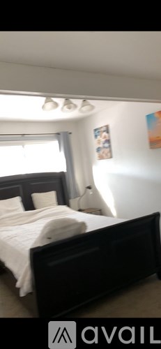 A bedroom with a bed and a painting on the wall.