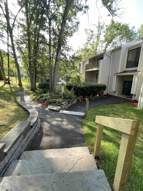 A wooden structure is in the foreground of a residential area with apartment buildings and trees.