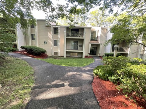 Apartment complex with a walkway in front.