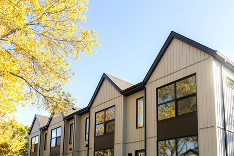 A modern building with a yellow tree in the foreground.