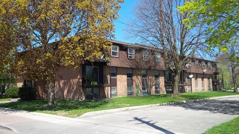 Apartment building with a tree in front of it.
