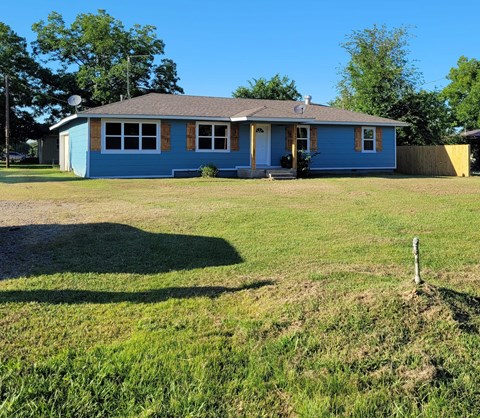 A blue house with a brown roof and a white door.