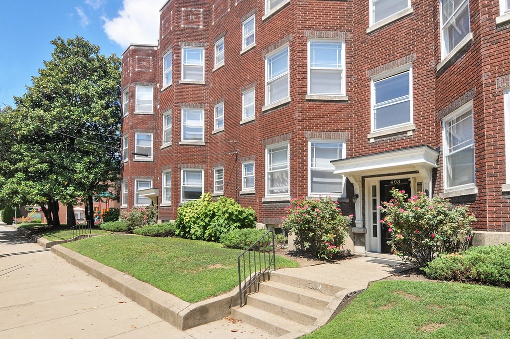 A red brick building with a white door and windows.