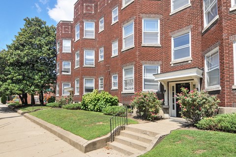 A red brick building with a white door and windows.
