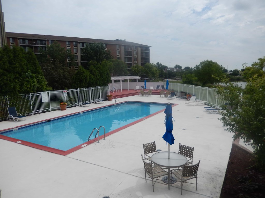 A pool with a table and chairs around it.