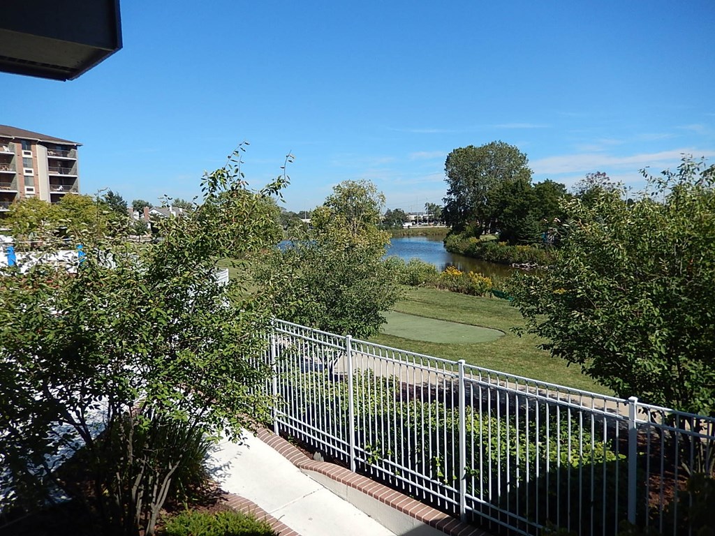 A view from a balcony overlooking a river and a golf course.