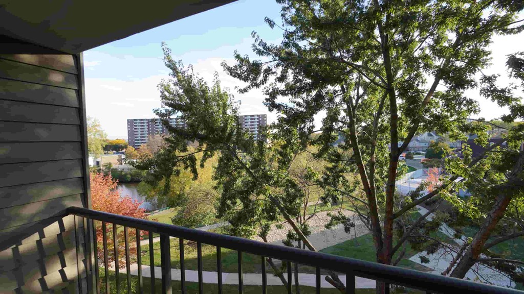 A balcony overlooks a river and buildings.