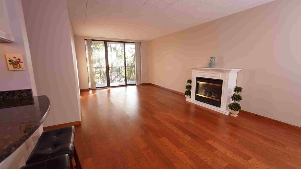 A living room with a fireplace and a black chair.