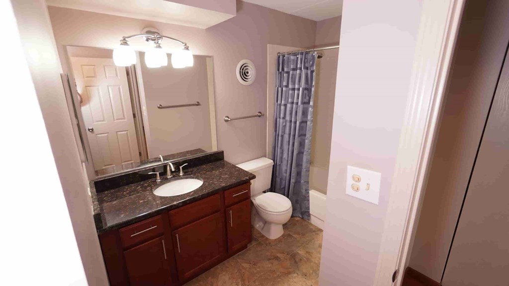 A bathroom with a sink, toilet, and shower.