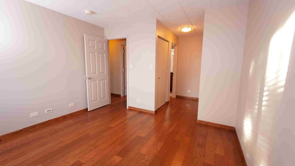 A room with wooden floors and two doors.