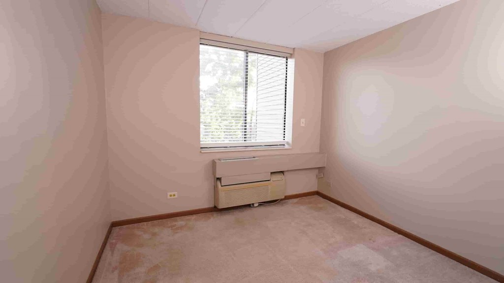 A room with a window and air conditioner.