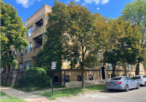 A street view with a car parked on the side of the road and a building in the background.