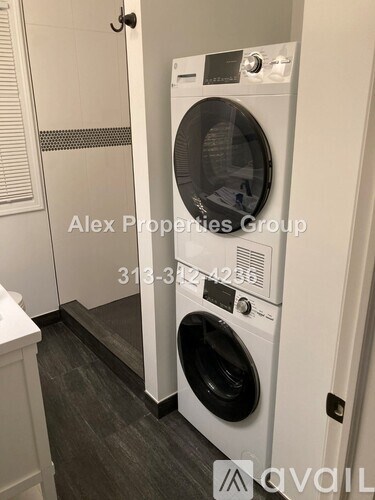 A white front loading washing machine in a laundry room.