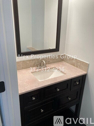 A bathroom vanity with a sink, mirror, and cabinet.