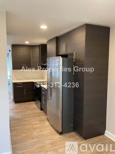 A kitchen with a refrigerator, cabinets, and a countertop is available for rent.