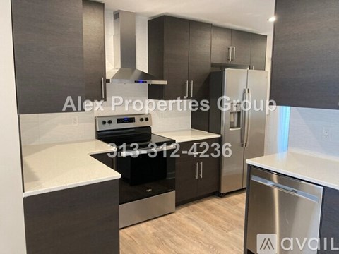 A modern kitchen with a stove top oven and a refrigerator.