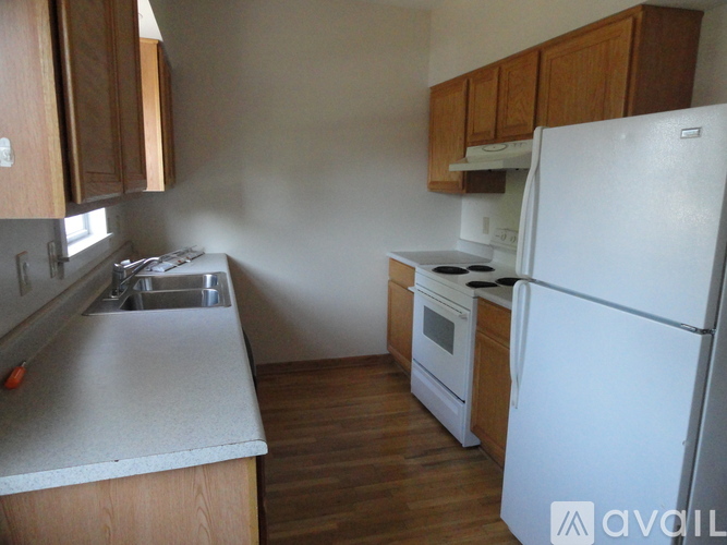 A kitchen with a white refrigerator, white stove, and white countertop.