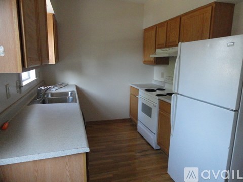 A kitchen with a white refrigerator, white stove, and white countertop.