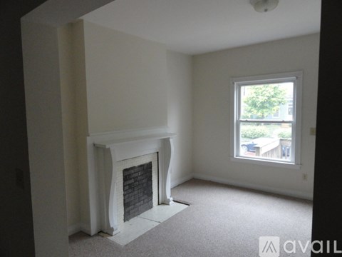 A room with a fireplace and a window.