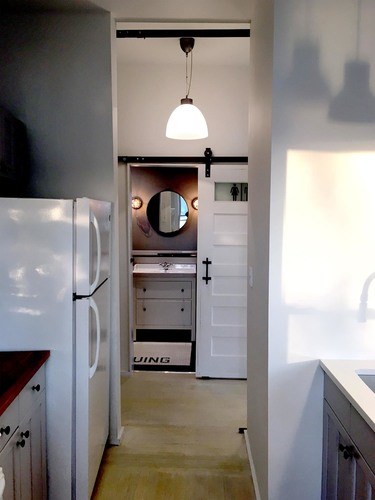 A white refrigerator is in a kitchen with a white door.