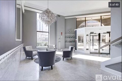 A modern living room with a grey sofa set and a chandelier.