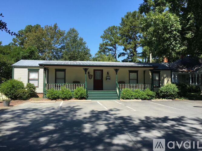 A house with a green front porch and a red door.