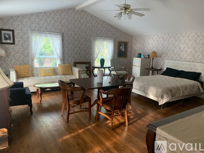 A bedroom with a bed, dresser, and chair.