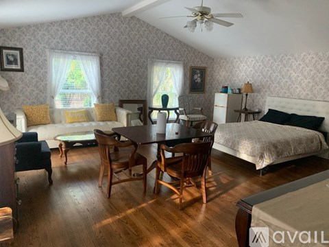 A bedroom with a bed, dresser, and chair.