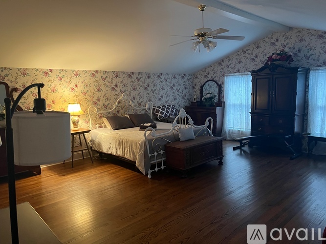 A bedroom with a bed, dresser, and ceiling fan.