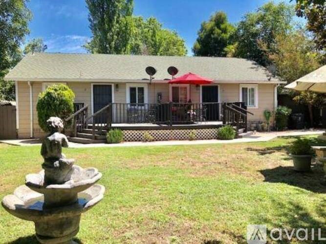 A house with a green roof and a fountain in front.