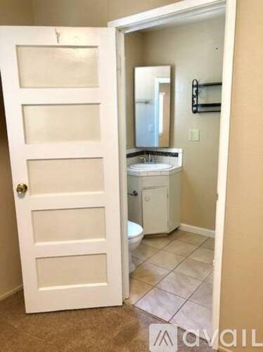 A bathroom with a toilet, sink, and mirror.