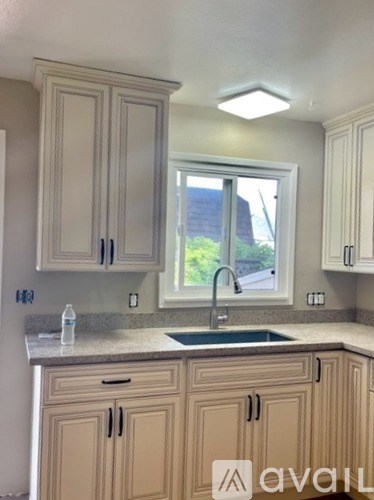 A kitchen with beige cabinets and a granite countertop.