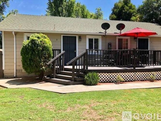 A house with a red umbrella on the porch.