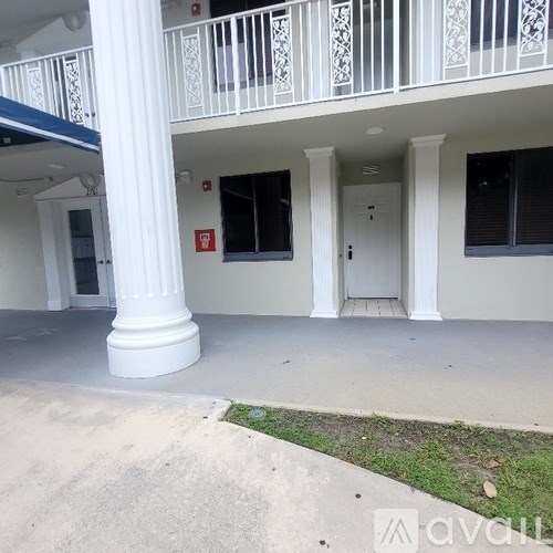 A white building with a balcony and columns.