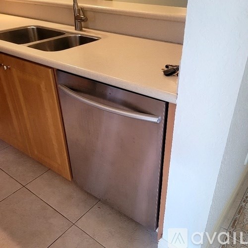 A kitchen with a stainless steel dishwasher and a sink.